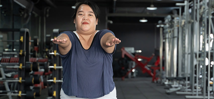 Heavy-set Asian woman exercising in gym