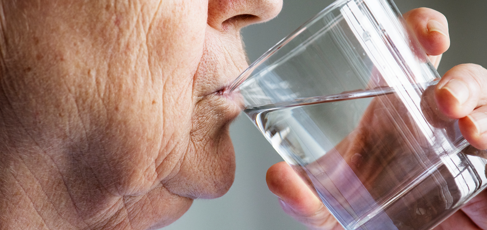 Close-up of senior woman drinking glass of water
