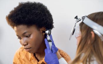 African American woman having her hearing tested by doctor