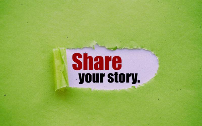 Green paper with piece torn out showing the words Share your story